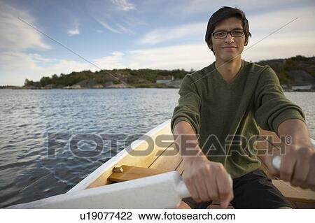 Stock Image - Young Man in rowing boat.. Fotosearch