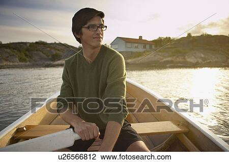 Young Man in rowing boat. View Large Photo Image Stock Image - Young Man in rowing boat.. Fotosearch