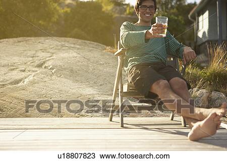 Young Man relaxing on Jetty. View Large Photo Image Stock Image - Young Man relaxing on Jetty.. Fotosearch