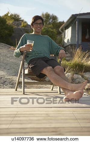 Young Man relaxing on Jetty. View Large Photo Image Stock Photograph - Young Man relaxing on Jetty.. Fotosearch