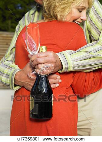 Couple embracing holding Champagne View Large Photo Image Stock Image - Couple embracing holding Champagne. Fotosearch