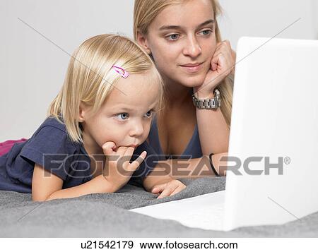 Stock Photo - Daughter and mother looking at a laptop. Fotosearch