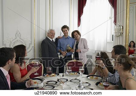 Grandparents presenting trophy to teenage boy (15-17) at family gathering View Large Photo Image Stock Image - Grandparents presenting trophy to teenage boy (15-17) at family gathering. Fotosearch