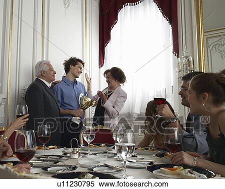 Grandparents presenting trophy to teenage boy (15-17) at family gathering View Large Photo Image Stock Photography - Grandparents presenting trophy to teenage boy (15-17) at family gathering. Fotosearch