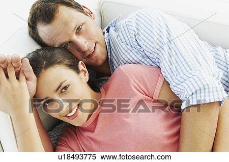 Happy couple embrace on sofa View Large Photo Image Stock Photography - Happy couple embrace on sofa. Fotosearch