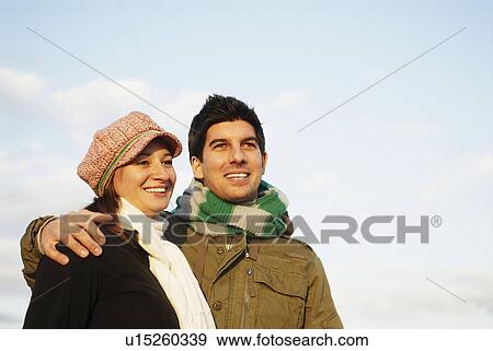 Stock Photo - Happy couple looking towards horizon. Fotosearch