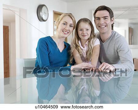 Stock Photo - Portrait of family at kitchen table. Fotosearch