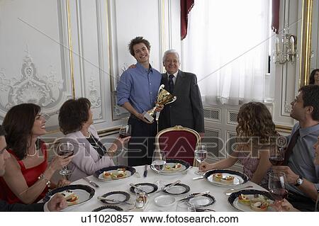 Senior man and teenage boy (15-17) with trophy at family gathering View Large Photo Image Stock Photo - Senior man and teenage boy (15-17) with trophy at family gathering. Fotosearch