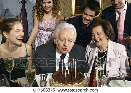 Senior man blowing out candles on cake View Large Photo Image Stock Photograph - Senior man blowing out candles on cake. Fotosearch