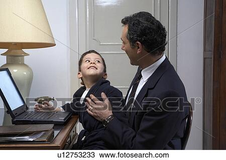 Son (4-6) smiling at father while using laptop View Large Photo Image Stock Image - Son (4-6) smiling at father while using laptop. Fotosearch