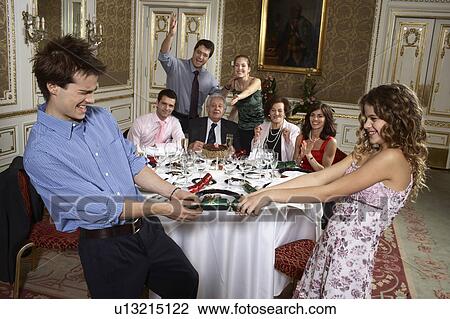 Teenage boy and girl (9-11) pulling cracker in at family gathering View Large Photo Image Stock Image - Teenage boy and girl (9-11) pulling cracker in at family gathering. Fotosearch
