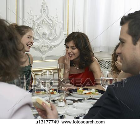 Two women talking at dinner table with family View Large Photo Image Stock Photo - Two women talking at dinner table with family. Fotosearch
