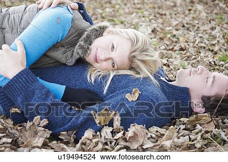 Woman relaxes on man in leaves View Large Photo Image Picture - Woman relaxes on man in leaves. Fotosearch