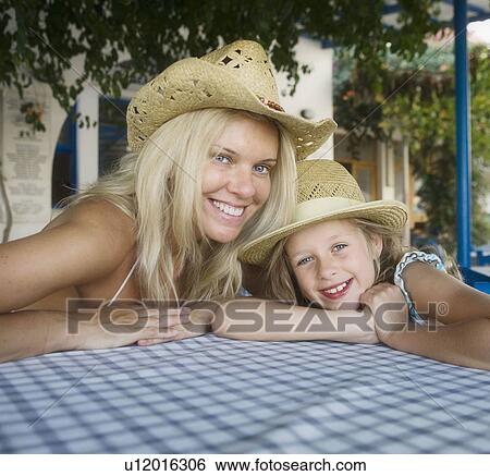Stock Photograph - Woman with young girl at an outdoor restaurant smiling.. Fotosearch