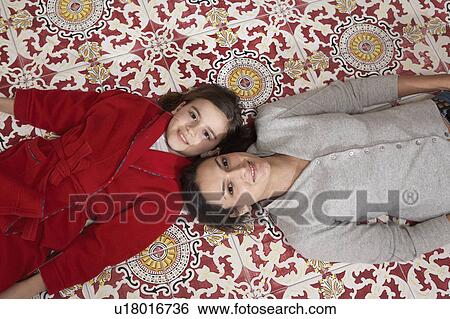 Young woman and daughter (9-11) lying on tiled floor, portrait View Large Photo Image Stock Photograph - Young woman and daughter (9-11) lying on tiled floor, portrait. Fotosearch