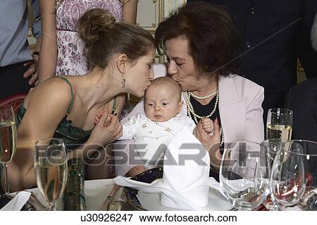 Stock Photo - Young woman and senior woman kissing baby( 3-6 month). Fotosearch