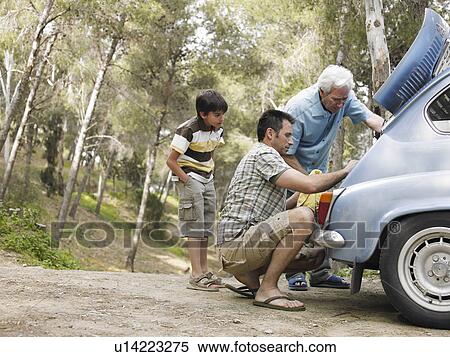 Boy (8-10) watching father and grandfather fixing car engine on country road View Large Photo Image Stock Photography - Boy (8-10) watching father and grandfather fixing car engine on country road. Fotosearch