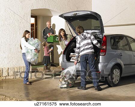 Stock Photography - Family loading car boot with recycling. Fotosearch