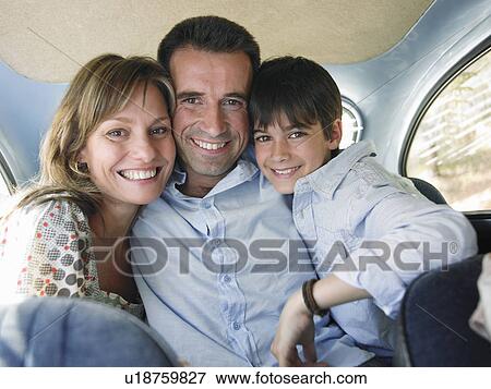 Stock Photo - Family sitting in backseat of car, smiling, portrait. Fotosearch