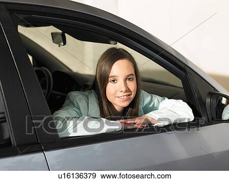 Girl (12-14) looking out of car window, smiling, portrait View Large Photo Image Stock Photo - Girl (12-14) looking out of car window, smiling, portrait. Fotosearch