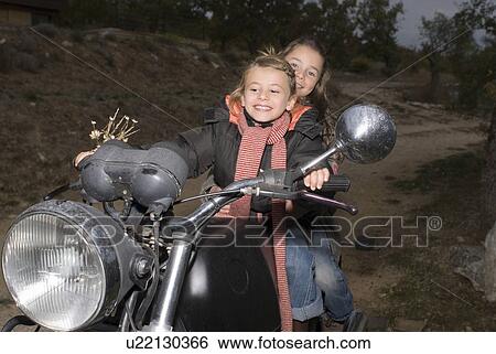 Stock Photograph - Girls riding an old bike.. Fotosearch