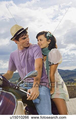 Stock Photograph - Man and woman on scooter.. Fotosearch