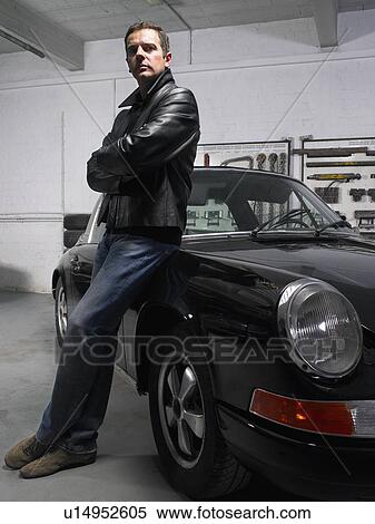 Man leaning on a Porsche in a garage. View Large Photo Image Stock Photography - Man leaning on a Porsche in a garage.. Fotosearch