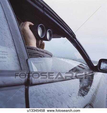 Man with binoculars peeking through car window. View Large Photo Image Stock Photo - Man with binoculars peeking through car window.. Fotosearch