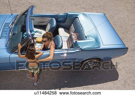 Stock Photo - Mother daughter by a car.. Fotosearch