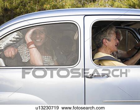 Stock Photo - Multi-generational family sitting in car, side view, smiling. Fotosearch