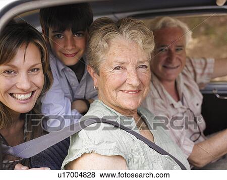 Stock Photo - Multi-generational family sitting in car, smiling, portrait. Fotosearch