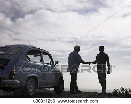 Senior man and adult son shaking hands beside parked car at beach View Large Photo Image Stock Photograph - Senior man and adult son shaking hands beside parked car at beach. Fotosearch