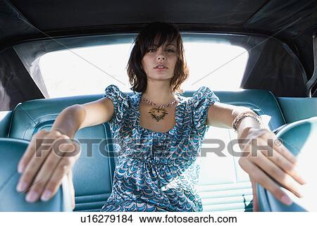 Picture - Woman in car holding front seats.. Fotosearch