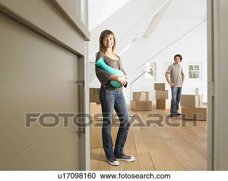 Stock Image - Couple moving into new home smiling.. Fotosearch