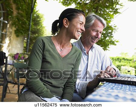 Couple on computer, laughing View Large Photo Image Stock Photography - Couple on computer, laughing. Fotosearch