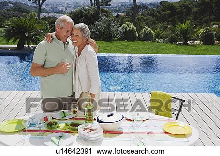 Man and woman embracing by poolside. View Large Photo Image Stock Image - Man and woman embracing by poolside.. Fotosearch