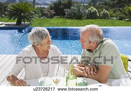 Stock Photo - Man and woman talking by poolside.. Fotosearch