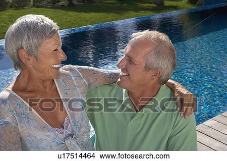 Picture - Older couple hugging on terrace.. Fotosearch