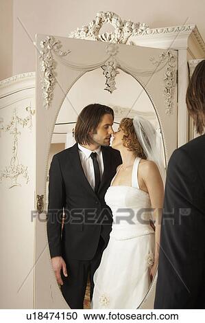 young bridal couple kissing reflected in wardrobe mirror View Large Photo Image Stock Image - young bridal couple kissing reflected in wardrobe mirror. Fotosearch