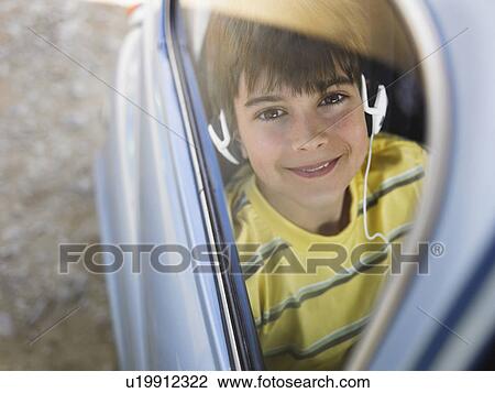 Boy (8-10) listening to music with headphones in backseat of car, portrait View Large Photo Image Stock Image - Boy (8-10) listening to music with headphones in backseat of car, portrait. Fotosearch