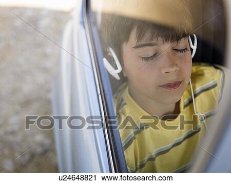 Boy (8-10) listening to music with headphones in backseat of car, eyes closed View Large Photo Image Stock Image - Boy (8-10) listening to music with headphones in backseat of car, eyes closed. Fotosearch