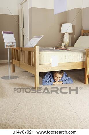 Boy hiding under bed in furniture store. View Large Photo Image Stock Image - Boy hiding under bed in furniture store.. Fotosearch
