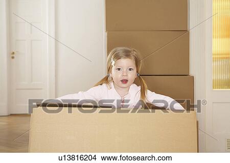 Picture - Girl (3-5) carrying large cardboard box, portrait. Fotosearch