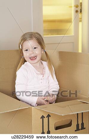 Girl (3-5) standing in cardboard box smiling, portrait View Large Photo Image Stock Photo - Girl (3-5) standing in cardboard box smiling, portrait. Fotosearch