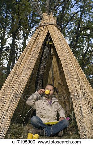 Stock Image - Kids playing in a teepee drinking tea.. Fotosearch