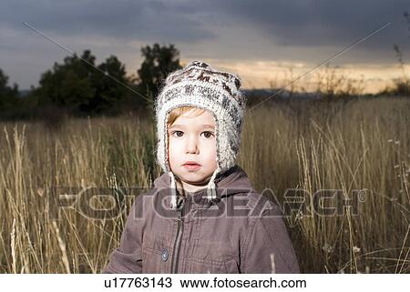Stock Image - Portrait of a boy in a field.. Fotosearch