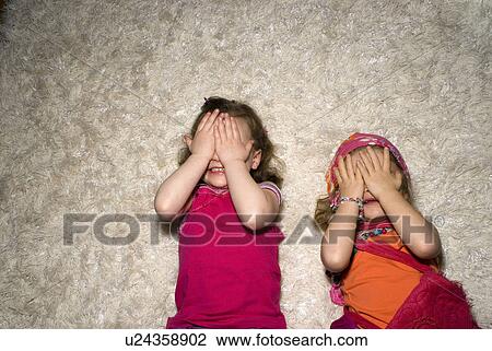 Two girls (2-4) dressed for a party, lying on rug. View Large Photo Image Stock Image - Two girls (2-4) dressed for a party, lying on rug.. Fotosearch