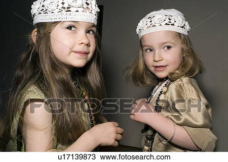 Stock Image - Two girls (2-4) having fun in party clothes.. Fotosearch