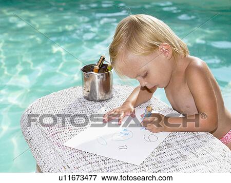 Stock Photo - Young boy coloring by a pool.. Fotosearch