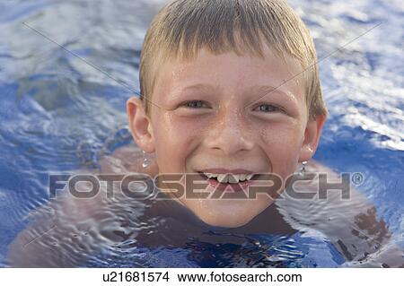 Young boy smiling in swimming pool. View Large Photo Image Picture - Young boy smiling in swimming pool.. Fotosearch